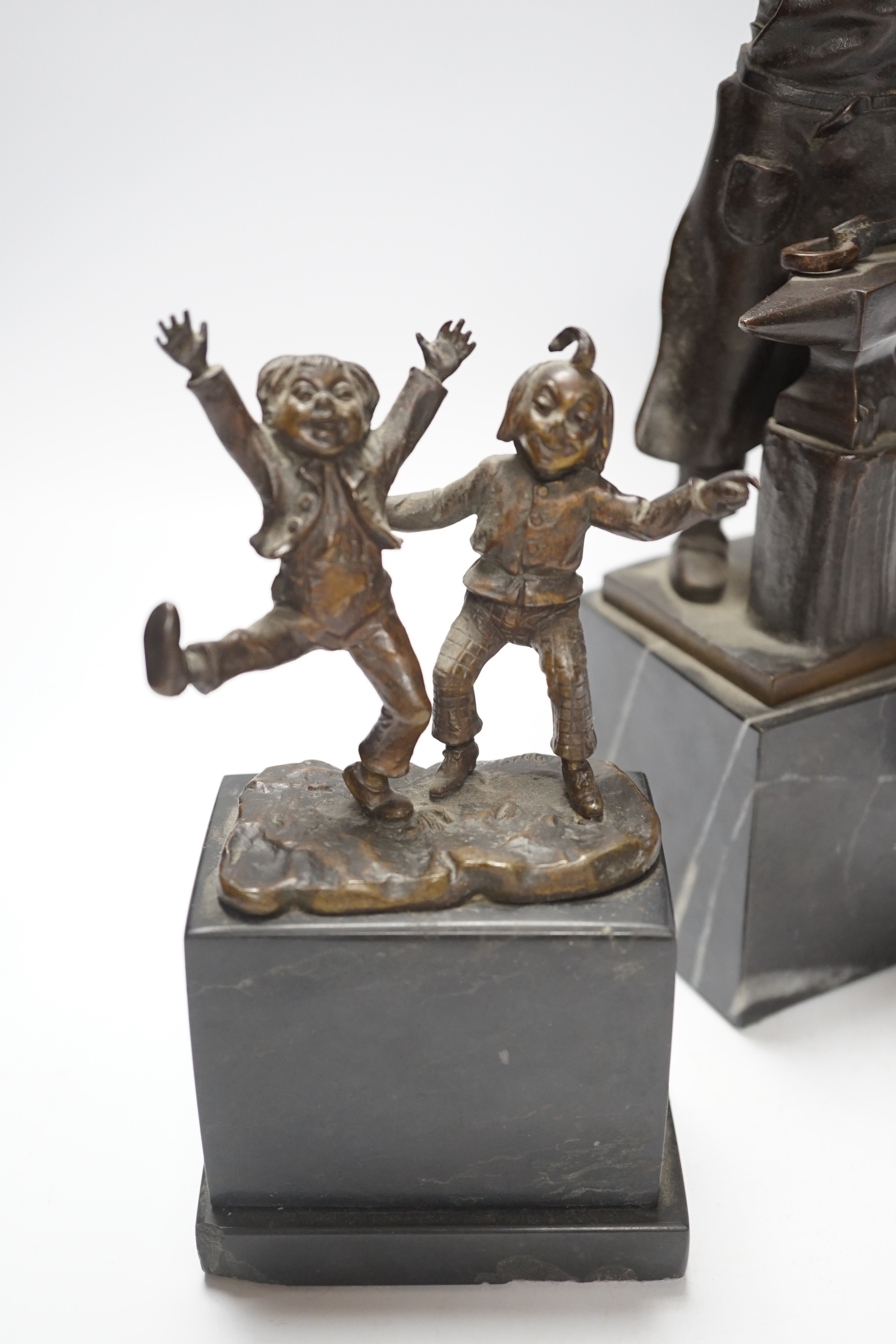 A German bronze of a blacksmith, indistinctly signed, a bronze figure group signed Öbold, a bronze of a Robin signed K. Reynen and an unsigned bronze of a ballerina, all on marble bases (4) tallest 27cm